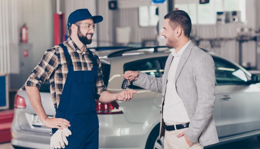 Kwik Kar technician handing car keys back to a customer